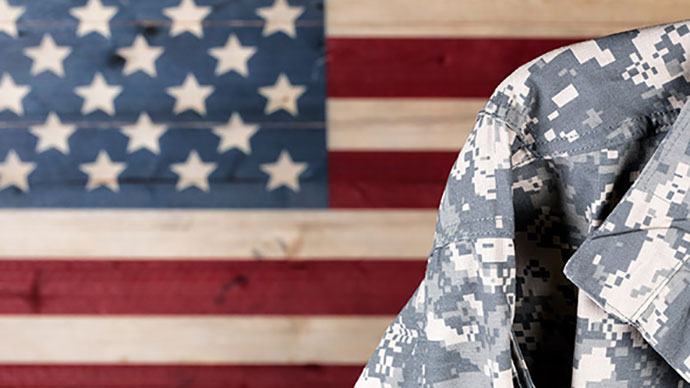 Military unifrom posing in front of an American flag